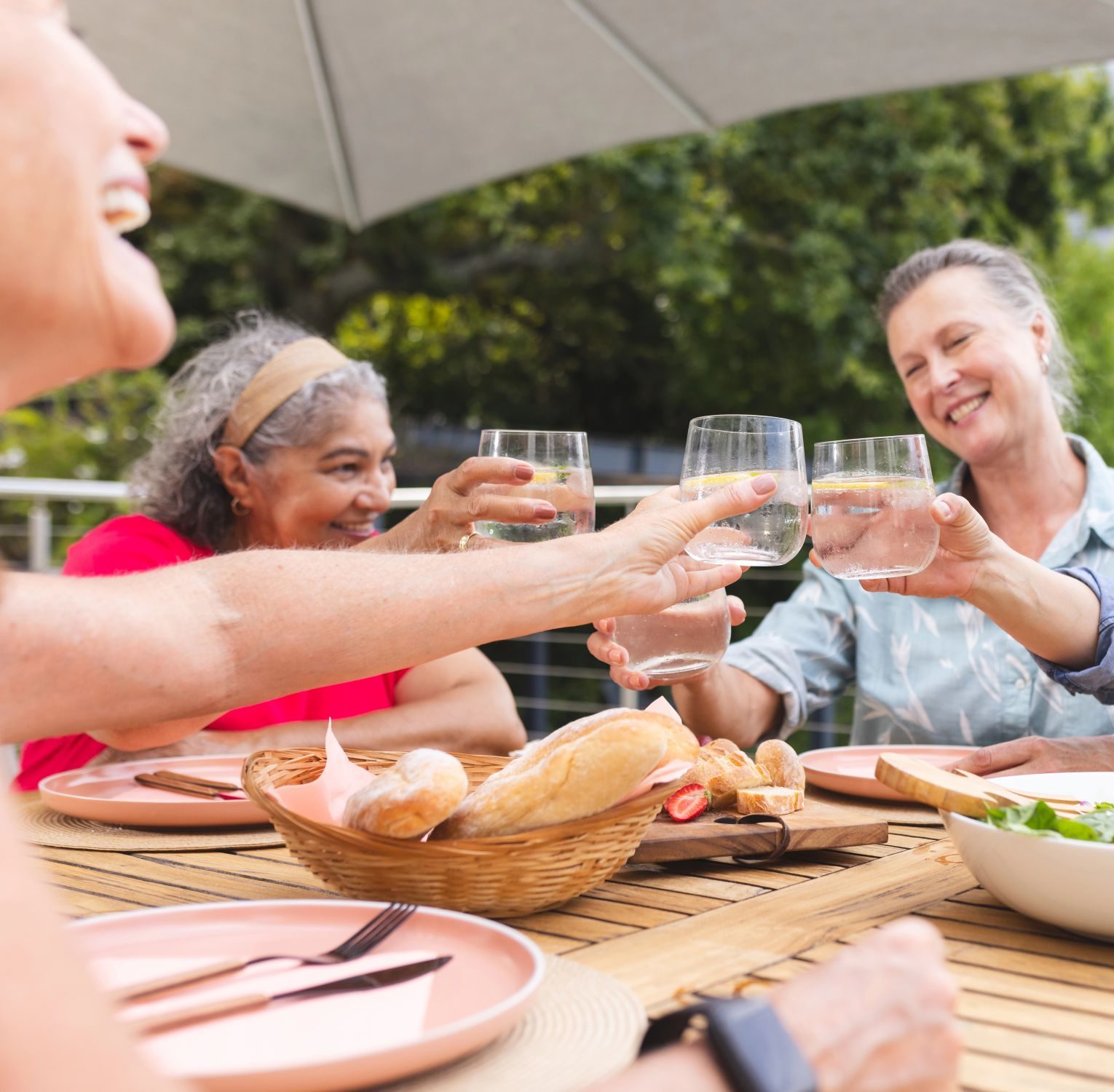 group-of-women-smiling Friends enjoying a meal together outdoors while celebrating good health